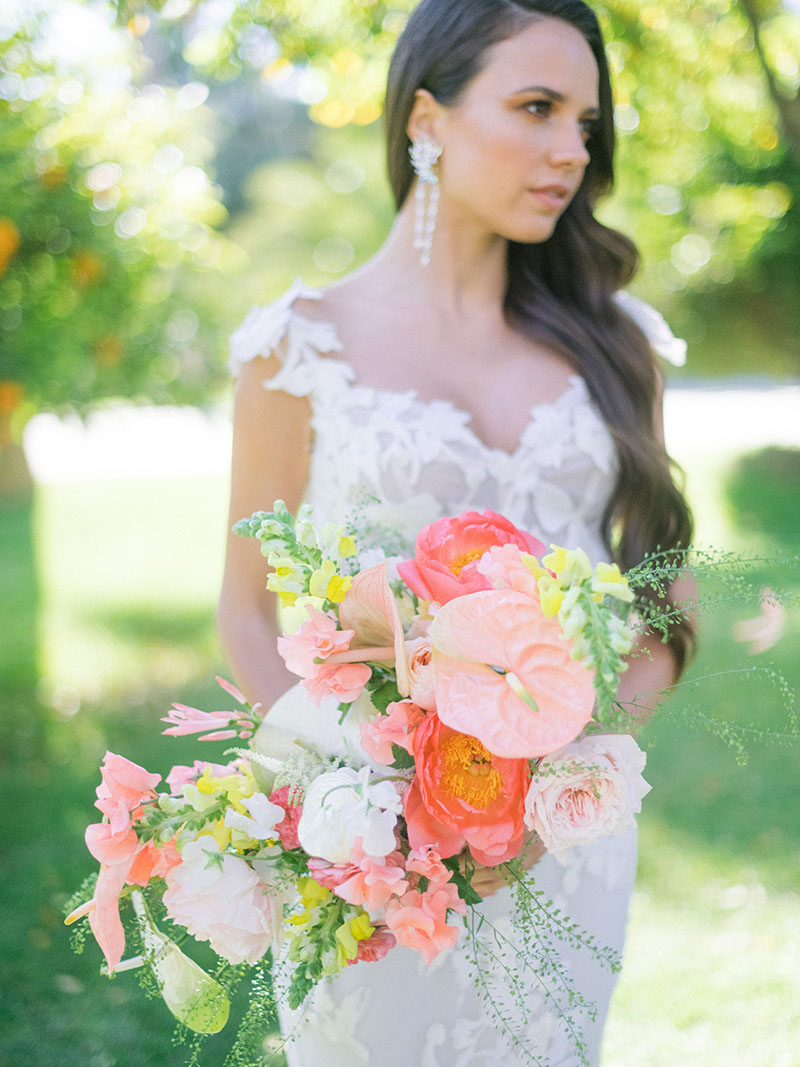une mariée tient un bouquet de flaurs
